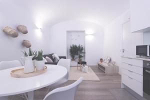 uma cozinha e sala de estar com uma mesa branca e cadeiras em Lavradores Boutique Guesthouse em Évora
