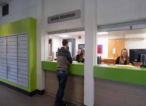 a man standing at a counter in a hospital at Au Campus-Hébergement hôtelier Université de Sherbrooke in Sherbrooke