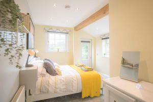 a bedroom with a bed with a yellow blanket at Nesscliffe in Llangollen