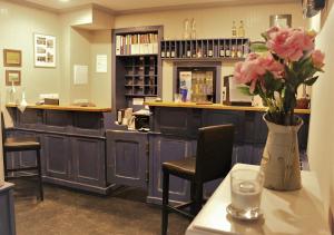 a bar with a vase of pink flowers on a table at Hotel Panský Dům Žamberk in Žamberk