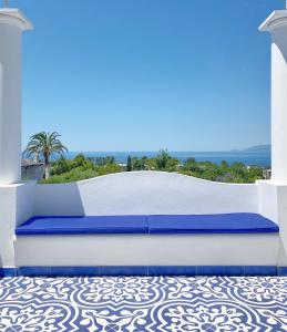 een blauw en wit bed bovenop een patio bij La Giuliva Charming Rooms in Anacapri