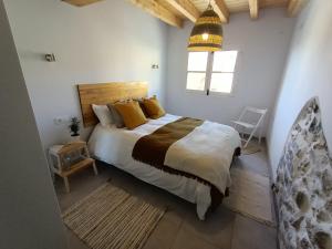 ein Schlafzimmer mit einem großen Bett und gelben Kissen in der Unterkunft The Little Caravia in Caravia + 20 Fotos