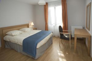 a bedroom with a bed and a desk and a table at Domitys Les Cigales du Lubéron in Cavaillon +17 photos
