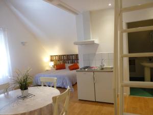 a bedroom with a bed and a table and a kitchen at LES PETITS JARDINS in Marcillac-Vallon +15 photos