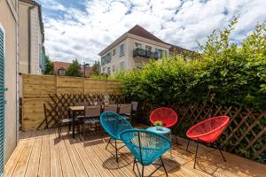 un patio con sillas y una mesa en una terraza de madera. en Disneyland House - Terrace - Sunny - Parking, en Serris