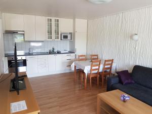 a living room and kitchen with a table and a couch at Bech's Hotell & Camping in Mo i Rana
