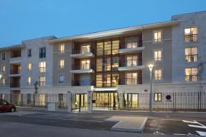 卡瓦永吕贝隆多米迪斯莱斯西加尔公寓的公寓大楼前面设有停车位