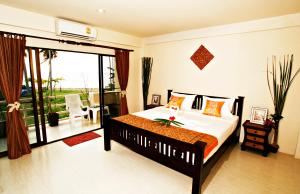 a bedroom with a bed and a balcony at Aloha Lanta in Ko Lanta