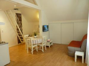 uma sala de estar com uma mesa e um sofá em LES PETITS JARDINS em Marcillac-Vallon