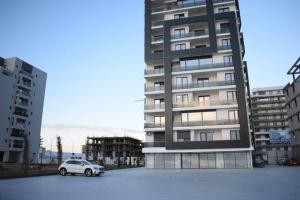 a car parked in a parking lot in front of a building at Apartment By The Lake with a View in Mamaia