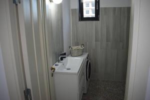 a small bathroom with a washer and dryer at Apartment By The Lake with a View in Mamaia +35 photos