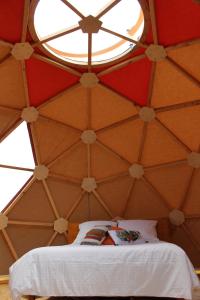 um quarto com uma cama numa tenda com uma janela em L'Attrape Rêve Insolite em Saint-Vincent-de-Barrès