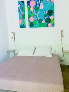 1 cama en una habitación con un cuadro en la pared en L'Islo Bamboo, en Saumane-de-Vaucluse