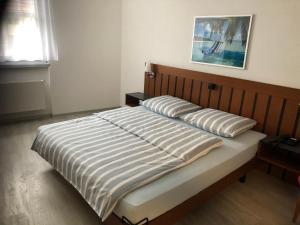 a bed with two pillows on it in a bedroom at Hotel Restaurant Passage in Grenchen