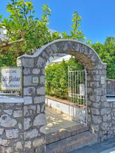 an entrance to a gate in a stone wall at La Giuliva Charming Rooms in Anacapri