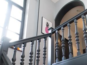 a stairway with a stair railing with a pineapple on the wall at Trankil Apparts centre in Saint-Quentin