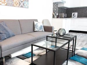 uma sala de estar com um sofá e uma mesa em Trankil'Apparts Centre em Saint-Quentin