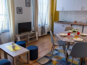 a living room with a table and a kitchen at Trankil'Apparts Centre in Saint-Quentin