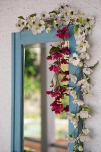 a wreath of flowers is hanging on a mirror at Tea House Gerês - T1 Hipericão in Geres