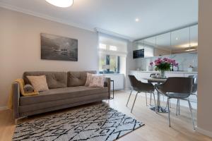 a living room and kitchen with a couch and a table at Altara Apartamenty Centrum - Free Parking in Zakopane