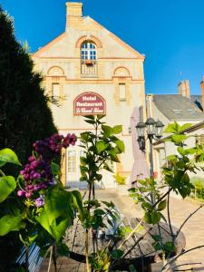 un edificio con flores púrpuras delante de él en Le Cheval Blanc, en Jargeau