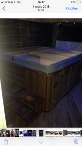 une baignoire en bois avec un comptoir bleu dans l'établissement Logement haut de gamme jacuzzi sauna, à Clermont-Ferrand