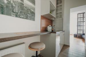 een keuken met een aanrecht en een kruk bij ZEUS Design Apartments Wasserwelt in Wenen