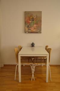 una mesa blanca con sillas y una pintura en la pared en Urban Living Belvedere Studio, en Viena