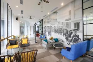 een lobby met een muurschildering van auto's op de muur bij Luminor Hotel Purwokerto By WH in Purwokerto