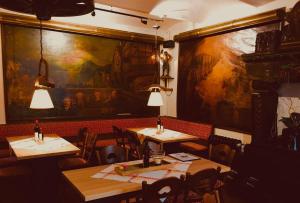 a restaurant with two tables and a large painting on the wall at Berg´s Backpacker in Rüdesheim am Rhein