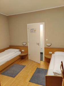 a room with two beds and a door with two rugs at Garni Maria in Varna