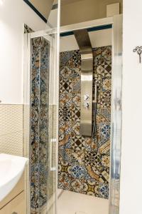 La salle de bains est pourvue d'une douche et d'un mur carrelé. dans l'établissement Mille una Notte, à Vasto