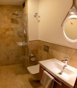 y baño con aseo, lavabo y ducha. en A.Emreli Suite Hotel, en Ayvalık