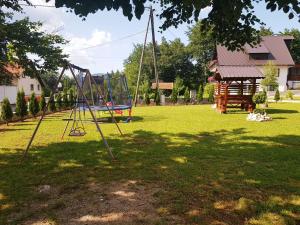 a park with a swing set in the grass at Guesthouse Green Valley in Plitvička Jezera