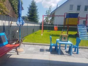 a playground with chairs and a table and a swing at Casa Perla Bianca in Rheinfelden