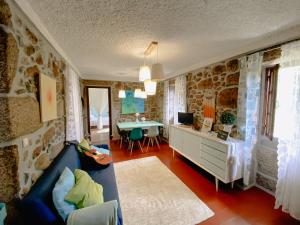 a living room with a stone wall at Tea House Gerês - T1 Hipericão in Geres