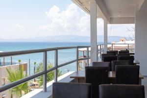 Un balcón con sillas y vistas al océano. en A.Emreli Suite Hotel, en Ayvalık