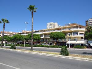eine leere Straße vor einem Gebäude mit Palmen in der Unterkunft Torreon del Mar Apartment in Benalmádena