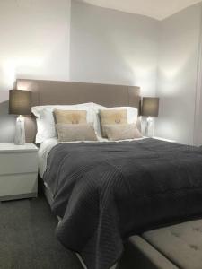 a bedroom with a large black bed with two lamps at Golden Cross Guesthouse in Oxford