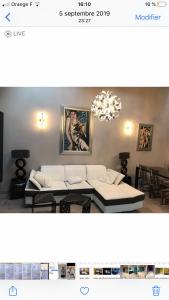 a living room with two beds and a chandelier at Logement haut de gamme jacuzzi sauna in Clermont-Ferrand