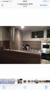 a kitchen with a counter top and a microwave at Logement haut de gamme jacuzzi sauna in Clermont-Ferrand