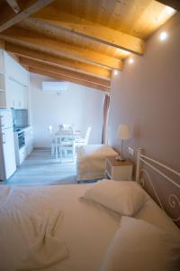 a bedroom with a bed and a kitchen with a table at Studios Artemis in Lefkada