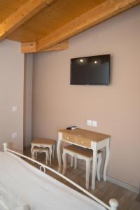 a room with a table and a tv on a wall at Studios Artemis in Lefkada