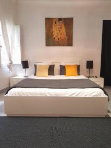 ボルドーにあるLes Cocons de Bordeauxのベッドルーム(白い大型ベッド、黄色い枕付)