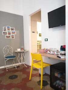 a yellow chair and a desk in a room at MiRhome Guest House in Rome