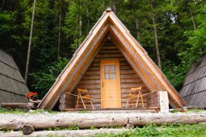 a log cabin with two chairs and a door at Camp ŠMICA in Luče