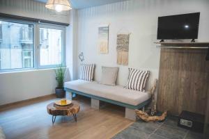 a living room with a couch and a tv at Rooster Suites in Athens