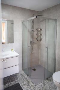 a shower with a glass door in a bathroom at Finca Tres Molinos B&B in Roldán