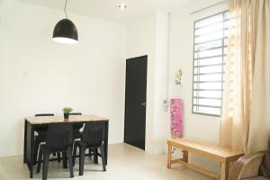 comedor con mesa negra y sillas en Cozy, Spacious, Air Cond UMP Gambang Homestay -- The Pigeon Guest House, en Kuantan