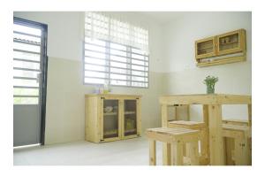 Cozy, Spacious, Air Cond UMP Gambang Homestay -- The Pigeon Guest House في كُوانتان: غرفة مع طاولة وكراسي ونافذة